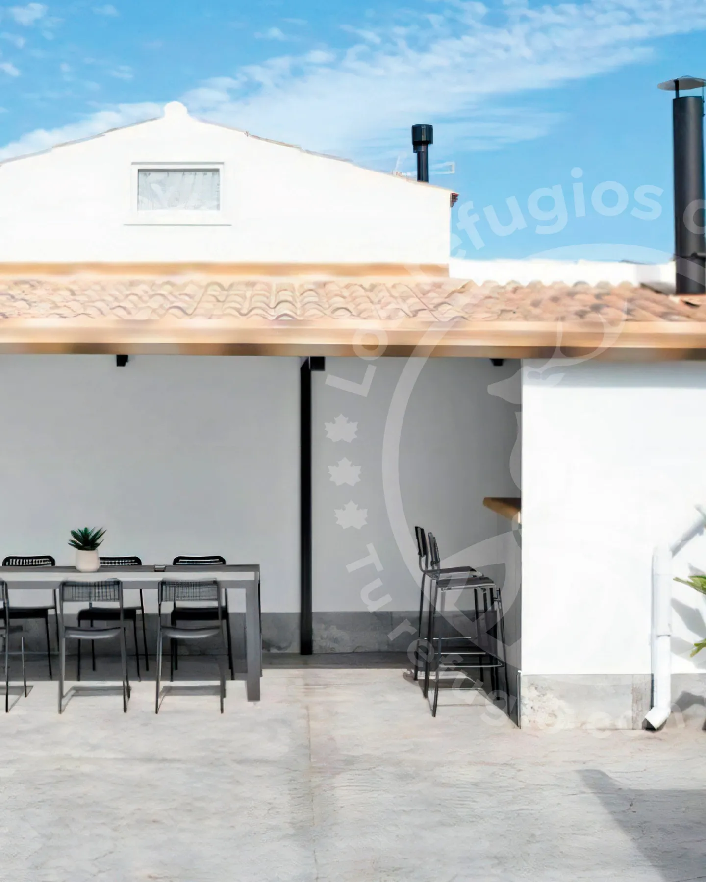 Covered terrace with table and stools in a house with pool in Chiclana