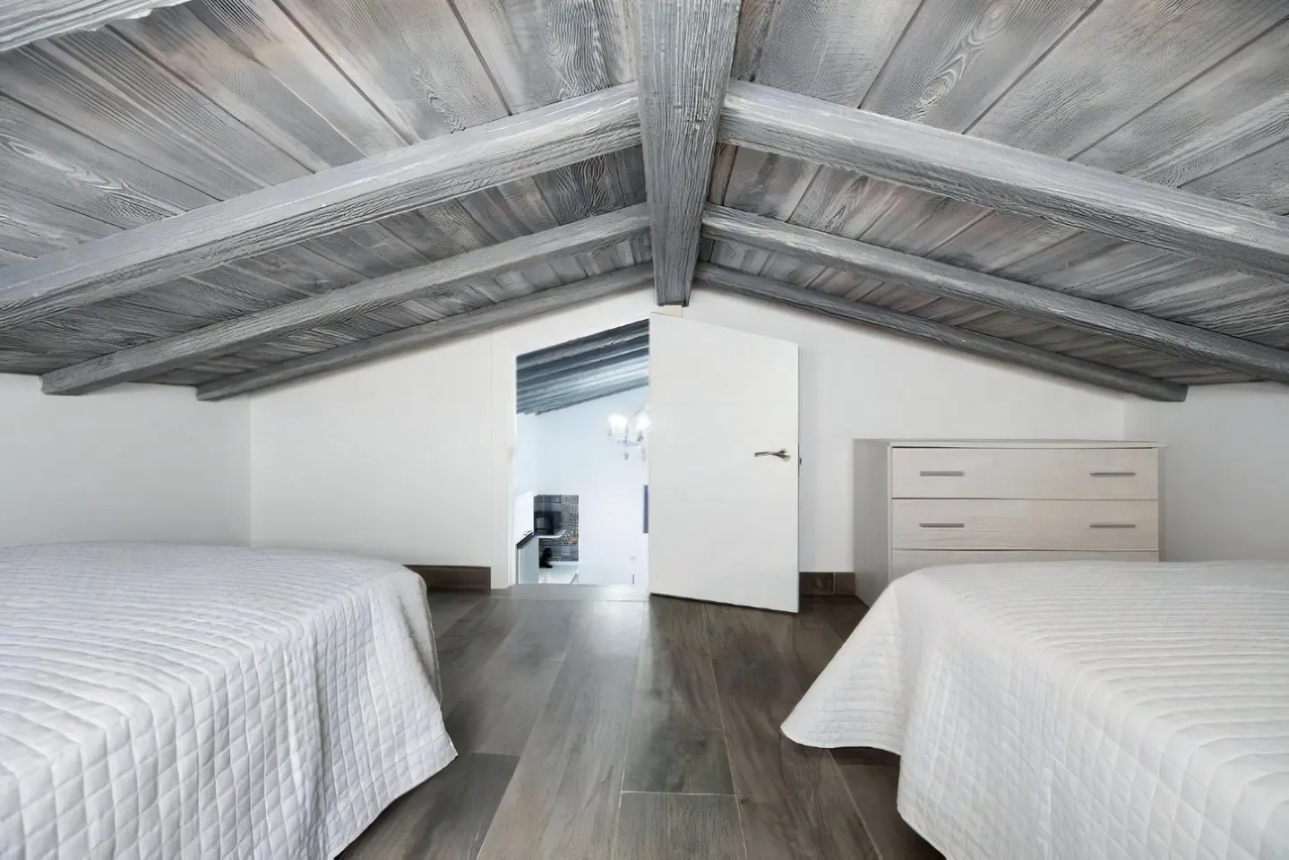 Attic bedroom of Casa Ferro with wooden beam ceiling