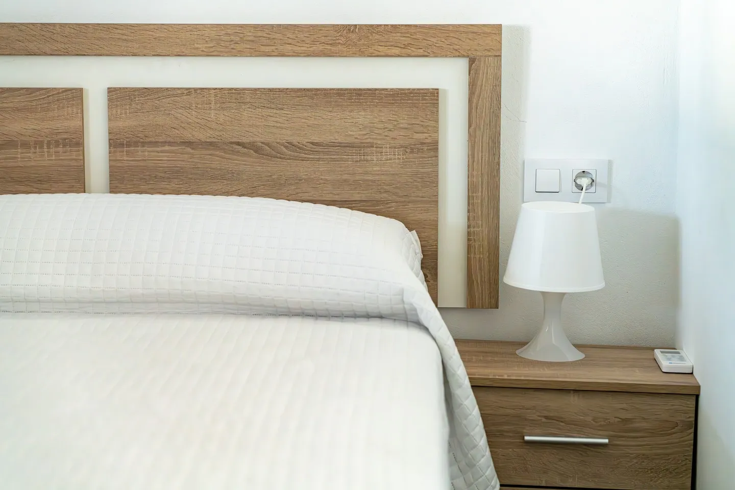 Bedroom at Casa Joal with a light wooden headboard and white bed linen