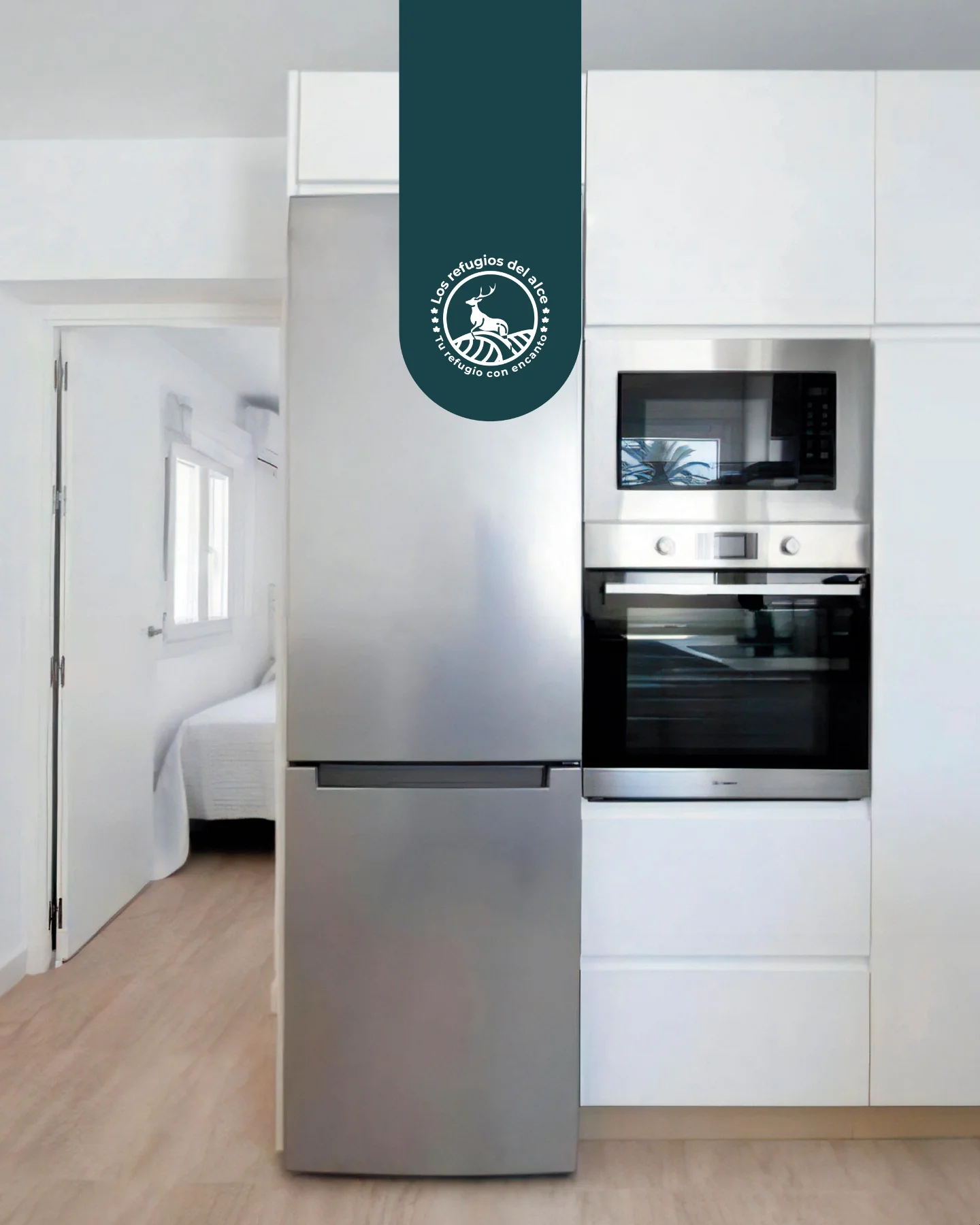 Kitchen with fridge and oven next to a bedroom