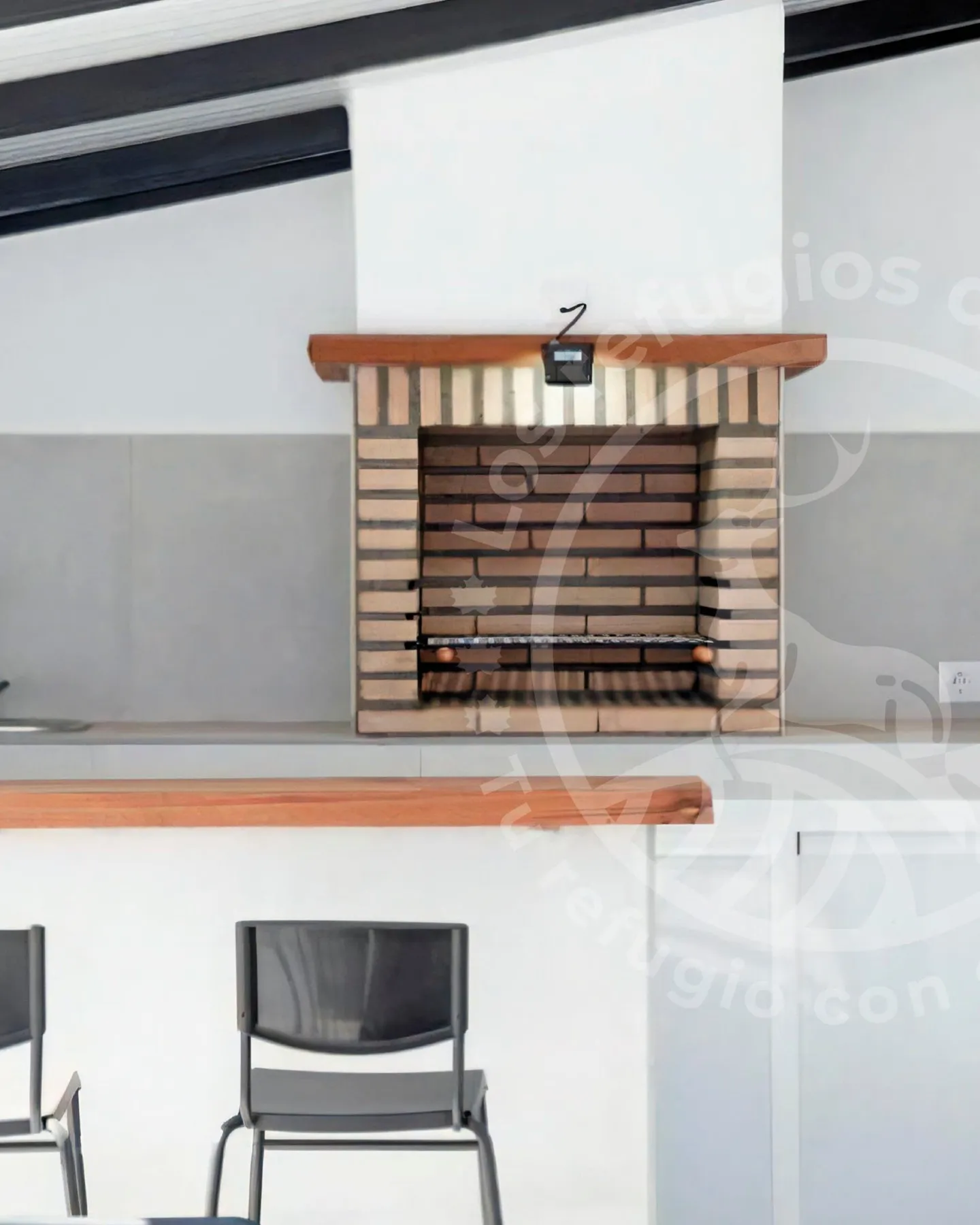 Brick barbecue under a barbecue porch with a wooden bar in a house in Chiclana